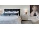 A serene bedroom features a cozy bed with an upholstered headboard, side table, and sophisticated decor at 14250 Sapelo Beach Dr, Orlando, FL 32827