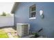 Exterior view of an AC unit next to a blue house with a window at 1460 Spring Ridge Cir, Winter Garden, FL 34787