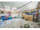 Cluttered garage with a concrete floor, toys, shelves, and a garage door at 1460 Spring Ridge Cir, Winter Garden, FL 34787