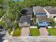 Aerial view showcasing homes with brick driveways and manicured lawns in a tree-lined neighborhood at 14835 Old Thicket Trce, Winter Garden, FL 34787