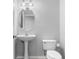 Clean half bath featuring a pedestal sink, oval mirror, and modern toilet at 14835 Old Thicket Trce, Winter Garden, FL 34787