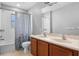 Bathroom with double sinks, toilet, and a shower with a blue patterned curtain at 14835 Old Thicket Trce, Winter Garden, FL 34787
