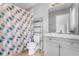 Stylish bathroom featuring a vanity and shower with patterned curtain at 14835 Old Thicket Trce, Winter Garden, FL 34787