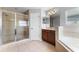 Elegant bathroom featuring a walk-in shower, and bath adjacent to vanity and a window at 14835 Old Thicket Trce, Winter Garden, FL 34787