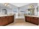 Bathroom featuring and sinks and a central drop-in soaking tub below two windows at 14835 Old Thicket Trce, Winter Garden, FL 34787