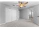 Bedroom featuring carpet floors, ceiling fan and a closet with door and view of ensuite at 14835 Old Thicket Trce, Winter Garden, FL 34787