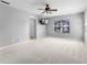 Spacious bedroom featuring neutral gray walls, carpeted floor, ceiling fan, and a wall-mounted television at 14835 Old Thicket Trce, Winter Garden, FL 34787