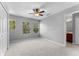 A spacious carpeted bedroom with three windows, closet and ceiling fan at 14835 Old Thicket Trce, Winter Garden, FL 34787