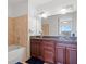 This bathroom includes a double vanity with granite countertops, tile walls, and a bathtub at 150 E Robinson St # 16B-2 1605, Orlando, FL 32801