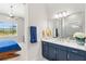 Bathroom featuring a large mirror, double vanity, and shower with natural light streaming through the window at 15049 Canopy Cover Dr, Winter Garden, FL 34787