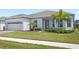 Beautiful single-story home with manicured landscaping, lush green lawn, and a welcoming entrance at 15049 Canopy Cover Dr, Winter Garden, FL 34787