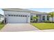 Charming single-story home showcasing manicured landscaping, brick driveway, and attached two-car garage at 15049 Canopy Cover Dr, Winter Garden, FL 34787