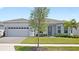 Charming single-story home featuring a well-manicured lawn and a two-car garage at 15049 Canopy Cover Dr, Winter Garden, FL 34787