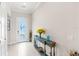Bright foyer with decorative table, white floors, and an exterior door at 15049 Canopy Cover Dr, Winter Garden, FL 34787