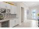 Hallway features tile floors, white cabinets with wine rack and quartz countertops at 15049 Canopy Cover Dr, Winter Garden, FL 34787