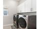 Laundry room with modern appliances, white cabinets, and a window for natural light at 15049 Canopy Cover Dr, Winter Garden, FL 34787