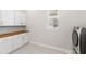 Laundry room showcasing white cabinets, countertops, a window, and modern appliances at 15049 Canopy Cover Dr, Winter Garden, FL 34787