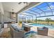 A covered patio features an outdoor kitchen, comfortable seating, and a pool with a screened enclosure at 15049 Canopy Cover Dr, Winter Garden, FL 34787