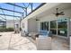 A covered patio features comfortable seating, an outdoor kitchen, and a pool with a screened enclosure at 15049 Canopy Cover Dr, Winter Garden, FL 34787