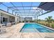 A luxurious pool and spa is surrounded by an outdoor kitchen and lounge area under a screened enclosure at 15049 Canopy Cover Dr, Winter Garden, FL 34787