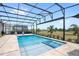 A luxurious pool and spa is surrounded by an outdoor kitchen and lounge area under a screened enclosure at 15049 Canopy Cover Dr, Winter Garden, FL 34787