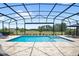 Stunning screened-in pool area with a spa, lush greenery, and picturesque views at 15049 Canopy Cover Dr, Winter Garden, FL 34787
