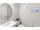 Chic powder room featuring a round mirror, modern faucet, and stylish decor for guests at 15049 Canopy Cover Dr, Winter Garden, FL 34787