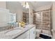 This bathroom features a double sink vanity, granite countertop, and enclosed walk-in shower at 1520 Mulligan Blvd, Davenport, FL 33896