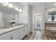 Bright bathroom featuring double sink vanity, granite counters, tile floors, and separate soaking tub at 1520 Mulligan Blvd, Davenport, FL 33896