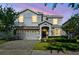 Charming two-story home showcasing lush landscaping and a paver driveway at 1520 Mulligan Blvd, Davenport, FL 33896