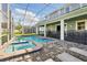 Screened in swimming pool and hot tub with brick paver deck, sun loungers, and covered patio for outdoor relaxation at 1520 Mulligan Blvd, Davenport, FL 33896