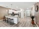 Open kitchen with white cabinets, bar seating, and tile floors leading to the hallway at 1520 Mulligan Blvd, Davenport, FL 33896