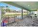 Covered pool patio with brick pavers, black metal safety fence, and outdoor dining area, ideal for relaxing and entertaining at 1520 Mulligan Blvd, Davenport, FL 33896