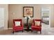 Cozy sitting area features red chairs, a decorative table, and artwork, creating a relaxing atmosphere at 1520 Mulligan Blvd, Davenport, FL 33896
