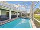 Screened in swimming pool with hot tub, covered patio, and beautiful landscaping, creating a relaxing and inviting outdoor space at 1520 Mulligan Blvd, Davenport, FL 33896