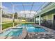 Swimming pool and hot tub with brick paver deck, and view of the lush backyard with mature landscaping at 1520 Mulligan Blvd, Davenport, FL 33896