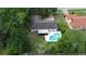 Aerial view of a home with a pool, screened-in patio, and well-maintained landscaping at 1525 Jaguar Cir, Apopka, FL 32712