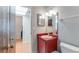 Bright bathroom featuring a red vanity, mirror, and toilet next to an open bedroom doorway at 1525 Jaguar Cir, Apopka, FL 32712
