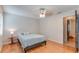 Inviting bedroom with laminate floors, a ceiling fan, and a view into the hall at 1525 Jaguar Cir, Apopka, FL 32712