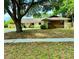 Sprawling ranch-style home with large shade tree and inviting front entrance at 1525 Jaguar Cir, Apopka, FL 32712
