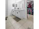 Bathroom featuring a double sink vanity, tile flooring, and a glimpse into an adjacent walk-in closet at 15356 White Tail Loop, Mascotte, FL 34753