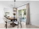 Bright breakfast nook with modern chandelier, round table, white chairs, and sliding glass doors to the outside at 15356 White Tail Loop, Mascotte, FL 34753