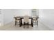 Dining room with a dark wood table, four chairs, neutral tile flooring and a large window with natural light at 15356 White Tail Loop, Mascotte, FL 34753