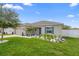 Beautiful home with lush green lawn and garden, complemented by modern exterior paint and a two-car garage at 15356 White Tail Loop, Mascotte, FL 34753