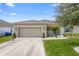 Charming single-Gathering home featuring a two-car garage, landscaped yard, and a cozy front porch at 15356 White Tail Loop, Mascotte, FL 34753