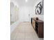 Bright hallway featuring neutral tile, modern decor, and a view of the front door at 15356 White Tail Loop, Mascotte, FL 34753