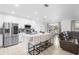Modern kitchen with stainless steel appliances, a spacious island with bar seating, and a view of the living area at 15356 White Tail Loop, Mascotte, FL 34753