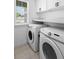 Laundry room featuring modern Samsung washer and dryer units, ample counter space, and natural light at 15356 White Tail Loop, Mascotte, FL 34753