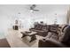 Open-concept living area with a large leather sectional sofa, tile flooring, and stainless steel kitchen appliances at 15356 White Tail Loop, Mascotte, FL 34753