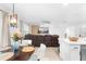 Well-lit living space showing a large leather sectional sofa and breakfast nook with seating at the kitchen counter at 15356 White Tail Loop, Mascotte, FL 34753